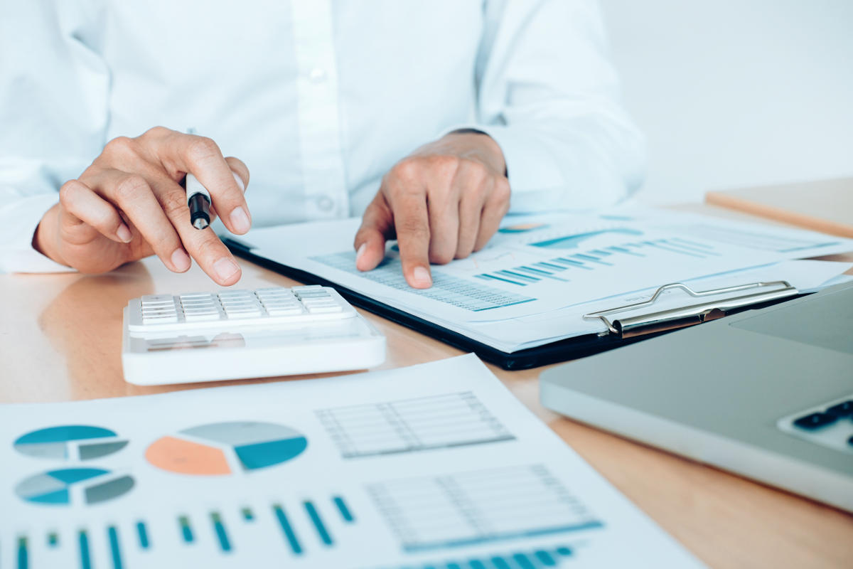 Analista revisando datos de balanza de pagos en computadora con gráficos económicos en México